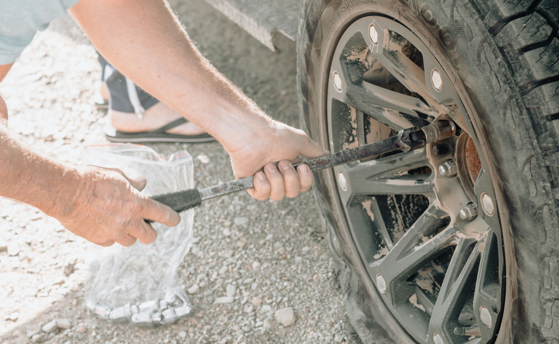 a man working on a tire with a wrench